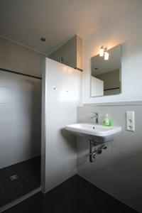 a bathroom with a white sink and a mirror at Ferien im Hummelhaus in Lindau
