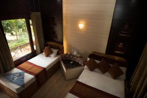 a room with two beds and a window at Chitwan Forest Resort , Chitwan National Park in Sauraha