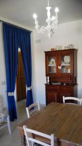 ガリポリにあるCasa Mare Gallipoliのダイニングルーム(テーブル、青いカーテン付)