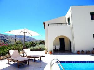 a villa with a swimming pool and an umbrella at Villa Anna in Asprouliánoi