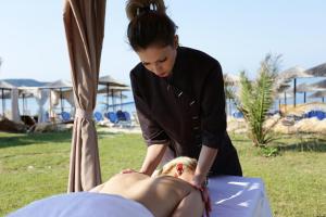 a woman is giving a woman a massage at Alexandra Beach Spa Resort in Potos