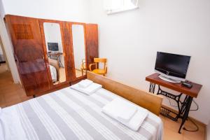 a bedroom with a bed and a tv on a table at La Casa Dei Ciottoli in Castelnuovo Cilento