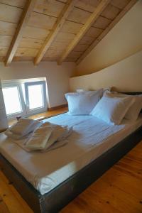 a large bed with white sheets and pillows in a room at Dolichi Studio in Samos