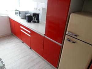 una cucina con armadi rossi e frigorifero rosso di Ferienwohnung Peter Hofling a Wertheim