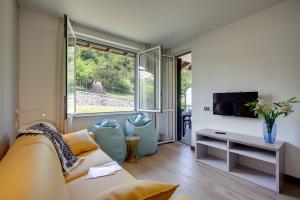 een woonkamer met een bank en een tv bij Residence Isolino in Verbania