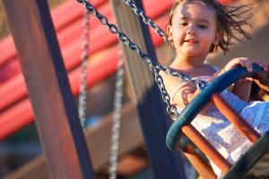 a little girl on a swing at a playground at Alexandra Beach Spa Resort in Potos