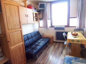 a living room with a couch and a table at Studio Zodiaque in Le Corbier