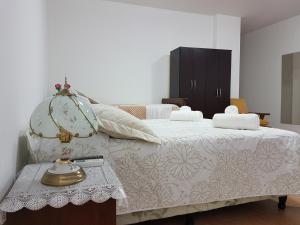 1 dormitorio con 1 cama y 1 mesa con lámpara en Casa Giovanini II en Puerto Iguazú