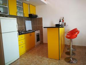 una cucina con armadi gialli e frigorifero bianco di Apartment Babovic Orahovac Kotor a Kotor (Cattaro)