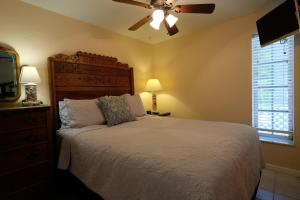 a bedroom with a bed and a ceiling fan at Seahorse Cottages - Adults Only in Sanibel