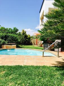 a swimming pool in a yard next to a house at Helderberg Guesthouse in Gordonʼs Bay