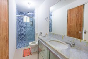 a bathroom with a sink and a toilet and a mirror at Cumbuco Kite Village Deluxe in Cumbuco