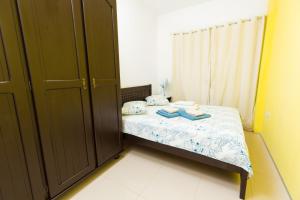 Dormitorio pequeño con cama y armario en Cumbuco Kite Village Deluxe, en Cumbuco