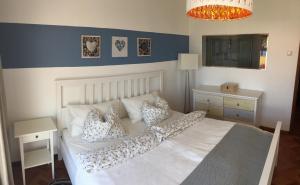 a bedroom with a white bed with pillows at Casa Matschinegg Madeira in Caniço