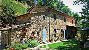 een oud stenen gebouw met een blauwe deur erop bij Agriturismo Tananei in Marliana