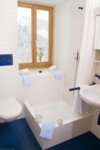 Hotel Veduta في Cinuos-Chel: حمام أبيض مع حوض ومغسلة