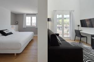 a bedroom with a bed and a living room with a desk at Hotel Flysch in Zumaia +41 photos