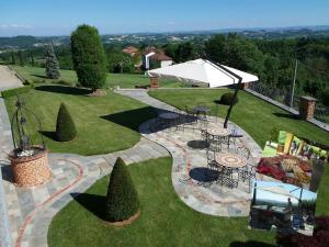 una vista aérea de un jardín con mesas y una sombrilla en B&B Cascina Bellavista, en Tigliole