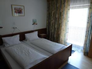 a large bed in a bedroom with a window at Gasthof Steinbräu in Faistenau