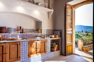 a kitchen with a counter and an open door at Fincahotel Can Estades in Calvia Town