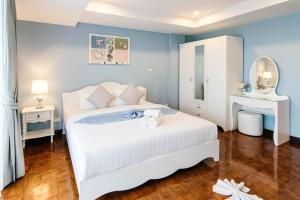 1 dormitorio con cama blanca y espejo en SeaRidge Hua Hin Resort & Poolvilla, en Khao Tao