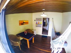 Habitación con mesa, sillas y hamaca. en Pousada Azul Marinho en Canoa Quebrada