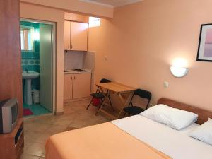 a room with two beds and a table and a kitchen at Antonio Apartments in Trogir