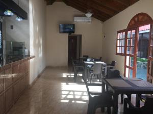 - une salle à manger avec des tables, des chaises et des fenêtres dans l'établissement Hotel Santander SD, à Saint-Domingue
