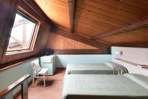 Zimmer im Dachgeschoss mit 2 Betten und einem Fenster in der Unterkunft Residence Lido Chelo in Bosa Marina