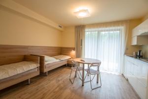 a small room with a table and a bed and a kitchen at Wiktoria in Wisła