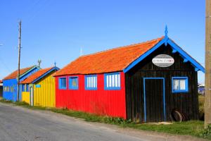 a row of colorful buildings on the side of a road at Maisonette de pays classée 3 étoiles in La Cotinière