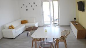 sala de estar con mesa blanca y sillas en Apartments Danica, en Promajna