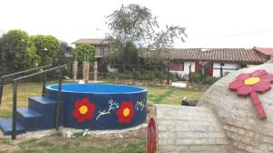 a barrel with flowers painted on it next to a house at Finca Saron Hostería & Spa in Sogamoso +14 photos