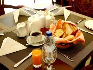 a table with a basket of bread and a bottle of juice at Arbella Boutique Hotel in Sharjah