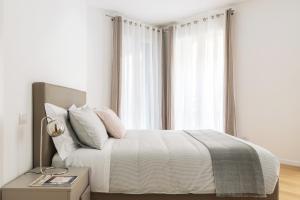 ミラノにあるALTIDO Sunny 1-bed flat with balconyの白いベッドルーム(窓付きのベッド付)