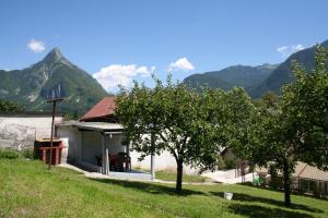 une maison avec des arbres et des montagnes en arrière-plan dans l'établissement Apartma Center, à Bovec