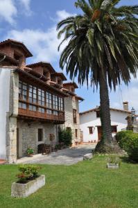 a building with a palm tree in front of it at Posada la Torre in Serdió