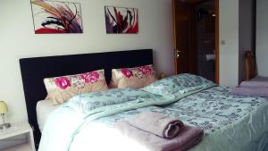 a bedroom with a bed with pink and green sheets and pillows at Alb Hotel Schalksburg in Albstadt