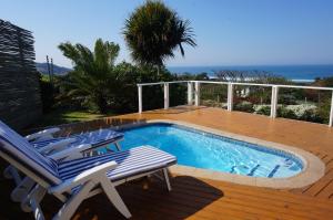 a swimming pool on a deck with two chairs next to it at CodsView Beach House in Pennington
