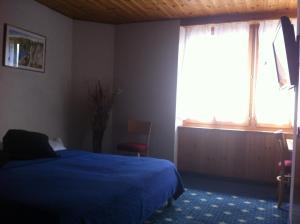 a bedroom with a blue bed and a window at OH!Berge in Chamoson