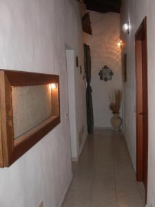 a hallway with a mirror on the wall at Locanda La Rosa in Pauli Arbarei