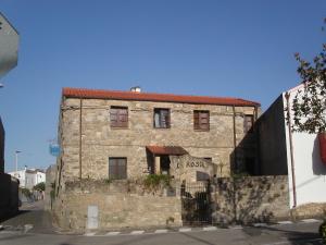 an old stone building on the side of a street at Locanda La Rosa in Pauli Arbarei