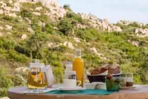 a table with food and orange juice and bread on it at Hotel Les Chambres de Mila Bonifacio in Bonifacio