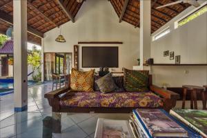 sala de estar con sofá y TV de pantalla plana en Ambary House Gili Trawangan- 2 BR Private Villa, Pool en Gili Trawangan