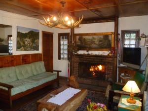 a living room with a couch and a fireplace at Hosteria Cumelen in San Martín de los Andes