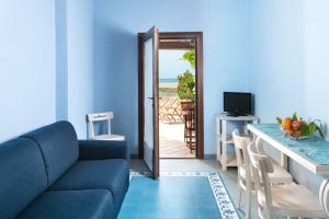 Sala de estar azul con sofá y mesa en Residence Lido Chelo en Bosa Marina