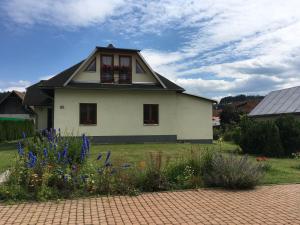 ein Haus mit einem Blumengarten davor in der Unterkunft Garden 35 in Ivachnová