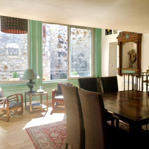 una sala da pranzo con tavolo, sedie e finestre di La Sarrasine ad Aiguèze
