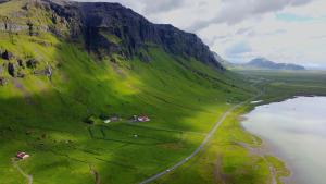Varmahlíð车库公寓的享有绿色山丘的空中景色,有水体
