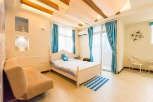 een slaapkamer met een bed, een stoel en een tafel bij Tainan Minuet in Tainan